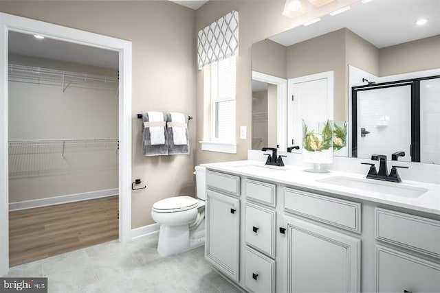 bathroom with hardwood / wood-style flooring, toilet, a shower with door, and vanity