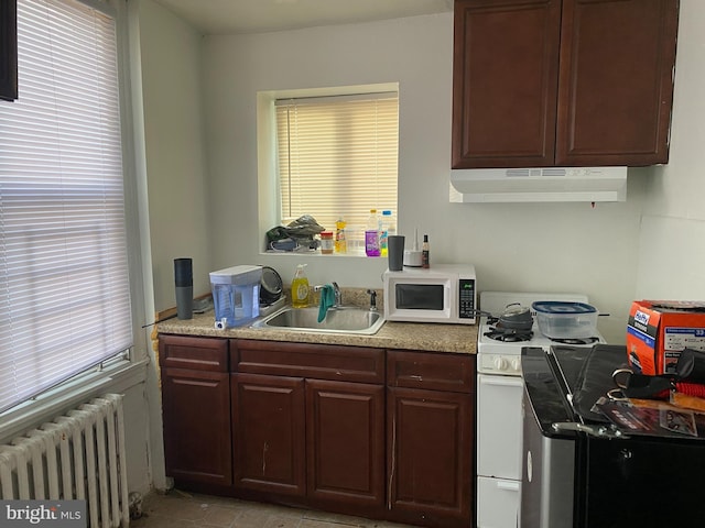 kitchen with radiator, sink, extractor fan, and white appliances