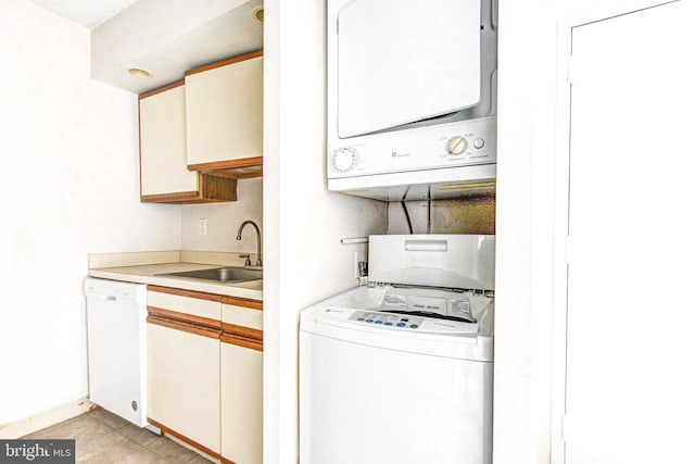 washroom featuring sink, light tile patterned flooring, and stacked washer / drying machine