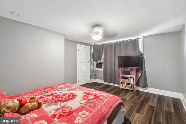 bedroom featuring ceiling fan, cooling unit, and dark hardwood / wood-style flooring