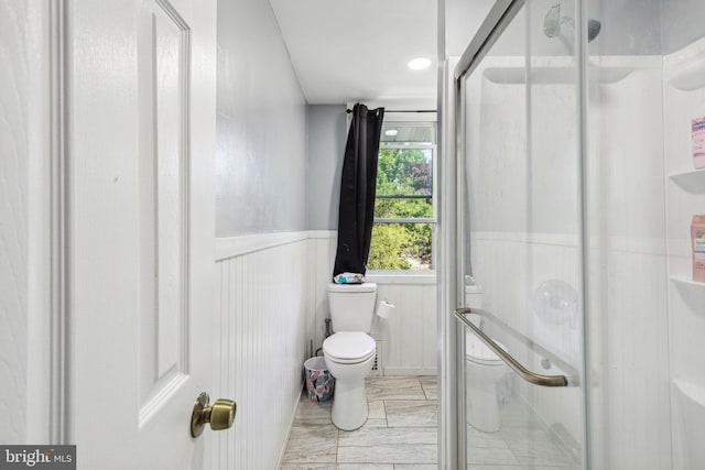 bathroom featuring toilet and an enclosed shower