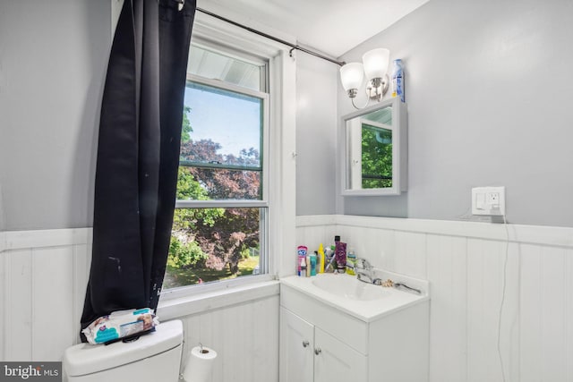 bathroom featuring vanity, a healthy amount of sunlight, and toilet