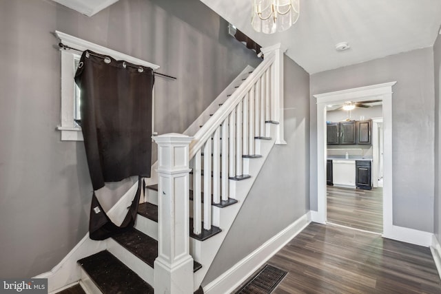 stairs with wine cooler, a chandelier, and wood-type flooring