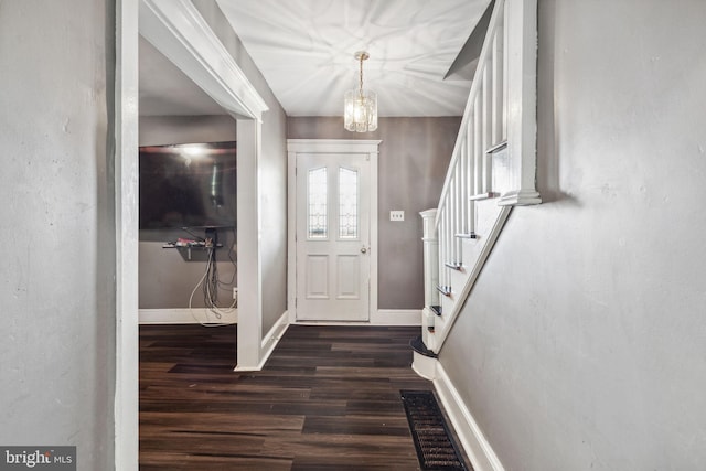 entryway with a chandelier and dark wood-type flooring