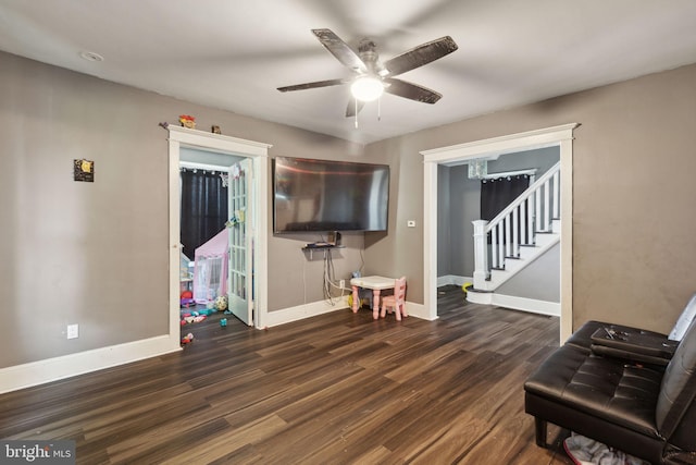 living area featuring dark hardwood / wood-style flooring and ceiling fan