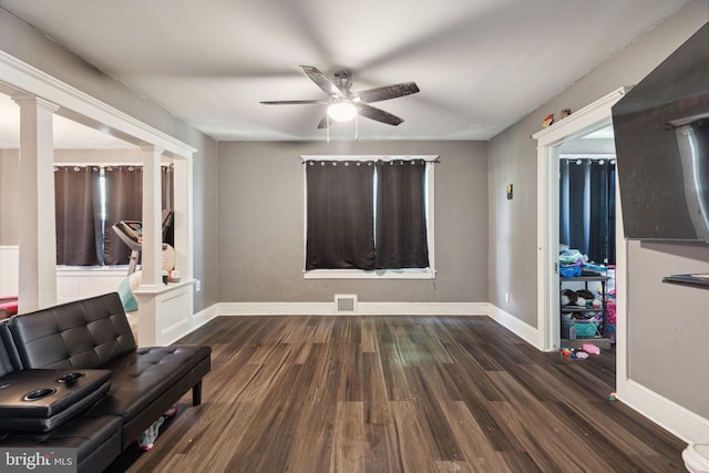 sitting room with dark hardwood / wood-style floors, ceiling fan, and decorative columns