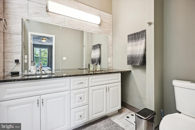 bathroom featuring tile patterned flooring, ceiling fan, toilet, and vanity