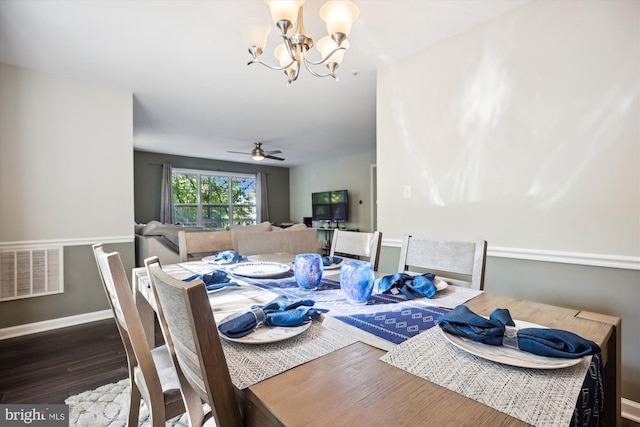 dining room with ceiling fan with notable chandelier and dark wood-type flooring