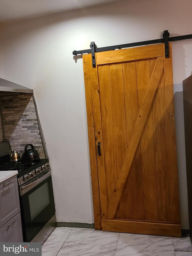 kitchen featuring black range with gas stovetop and a barn door