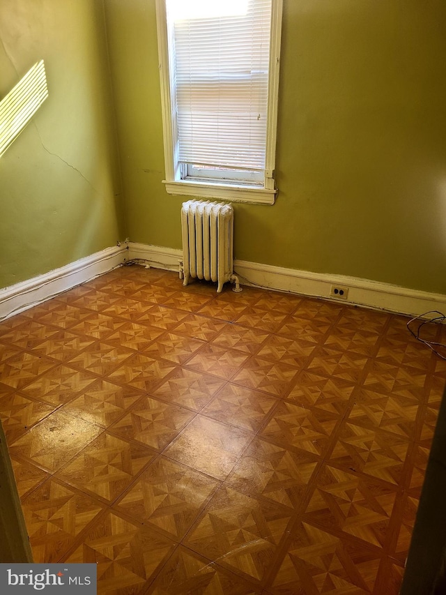 unfurnished room with radiator and parquet flooring