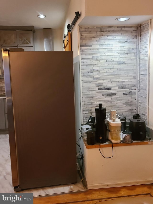 room details featuring a barn door and stainless steel fridge