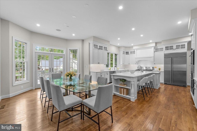 dining space featuring french doors, sink, and light wood-type flooring