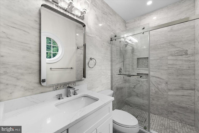 bathroom featuring toilet, an enclosed shower, vanity, and tile walls