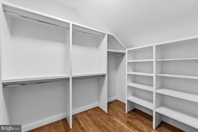 walk in closet featuring lofted ceiling and hardwood / wood-style flooring