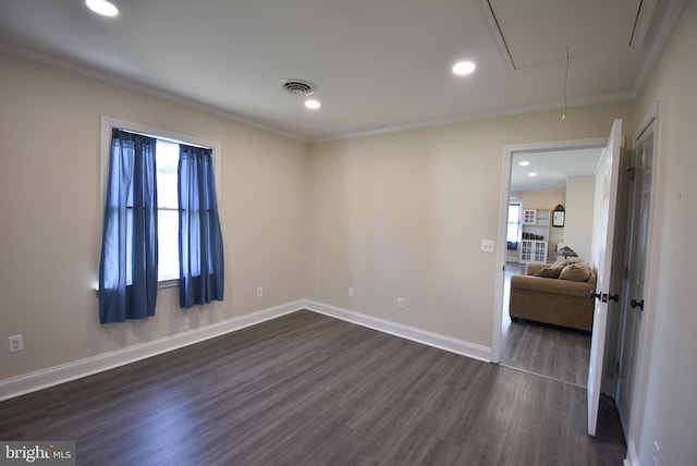 empty room with dark hardwood / wood-style floors and crown molding