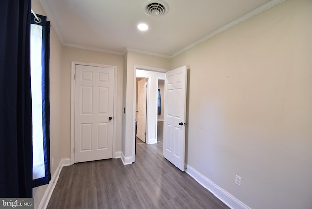 unfurnished bedroom with dark hardwood / wood-style flooring and ornamental molding