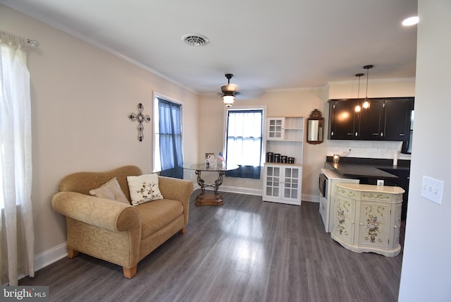 living area with ceiling fan, dark hardwood / wood-style floors, and ornamental molding