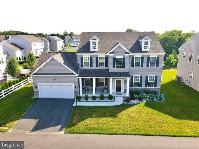 view of front facade with covered porch, a garage, and a front yard