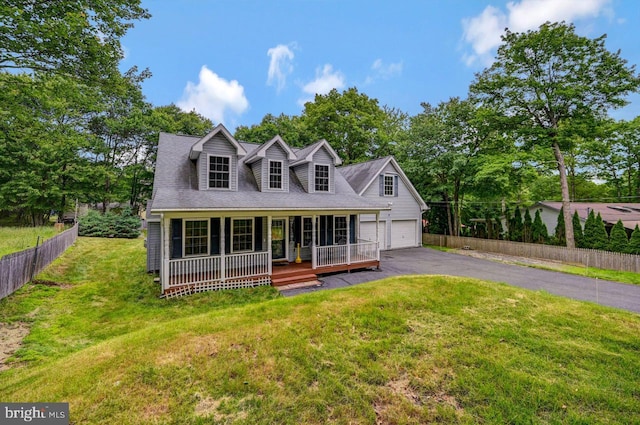 new england style home featuring a front lawn, a porch, and a garage