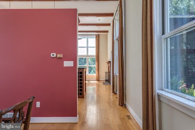 hall featuring beamed ceiling and light hardwood / wood-style floors