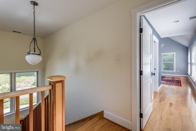 hall featuring light hardwood / wood-style flooring and lofted ceiling