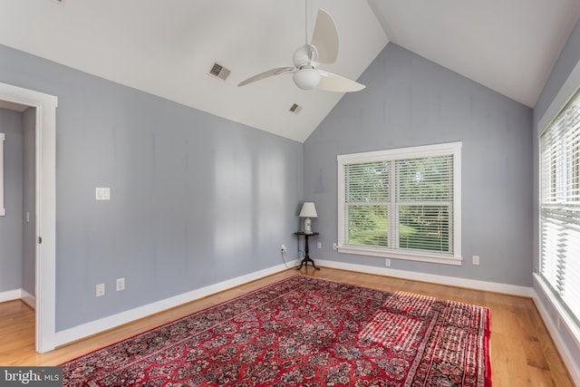 empty room featuring hardwood / wood-style floors, plenty of natural light, ceiling fan, and high vaulted ceiling