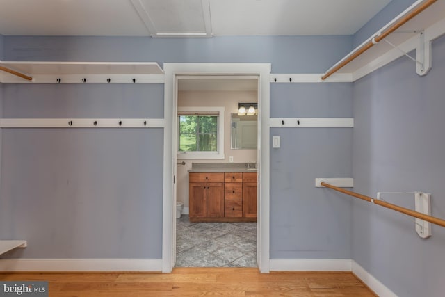 walk in closet with light wood-type flooring