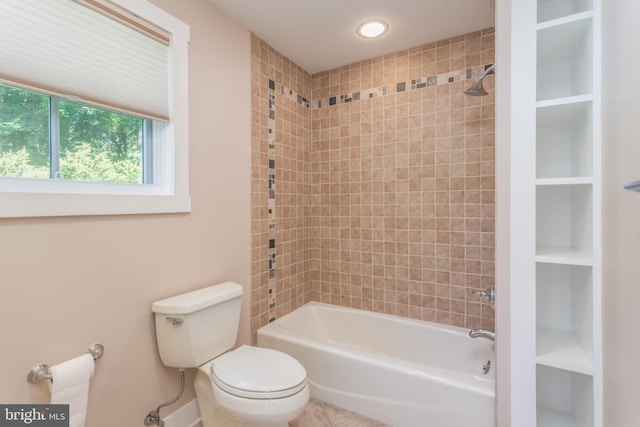 bathroom with built in features, toilet, and tiled shower / bath