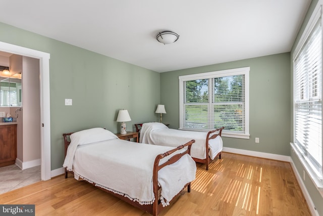 bedroom featuring multiple windows and light hardwood / wood-style floors