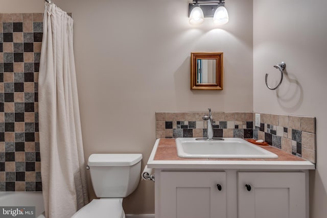 bathroom with decorative backsplash, vanity, and toilet