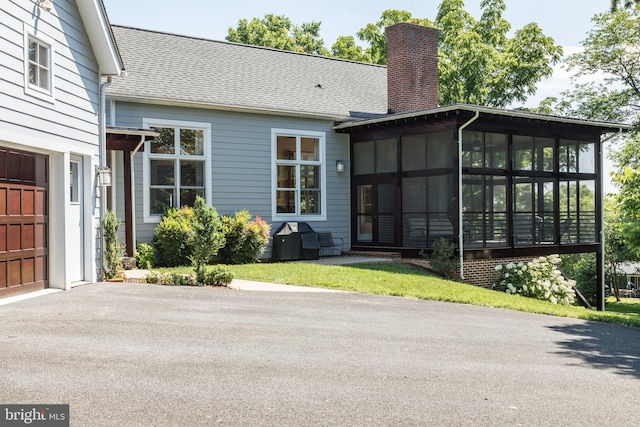 exterior space featuring a garage and a sunroom