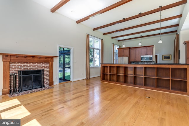 living room featuring a fireplace, beam ceiling, and light hardwood / wood-style floors