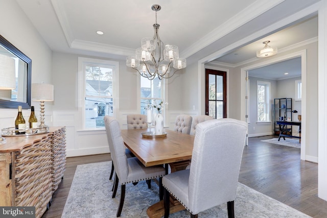 dining room featuring dark wood-type flooring, a notable chandelier, a healthy amount of sunlight, and crown molding