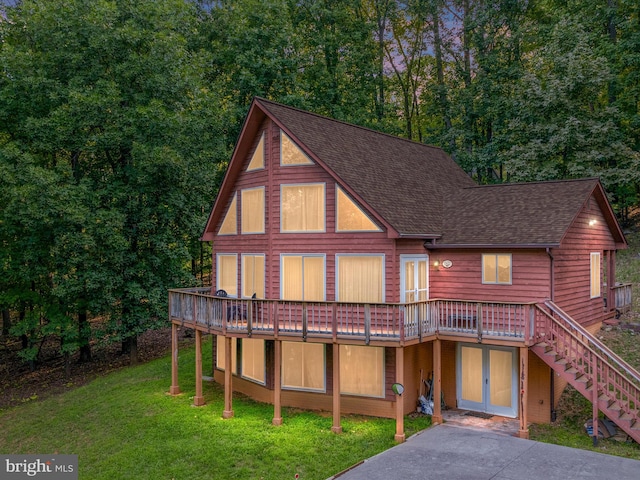 back of property featuring a lawn and a wooden deck