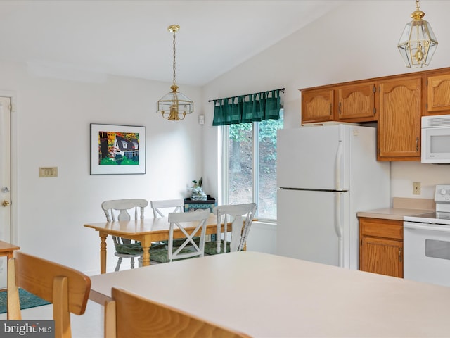 kitchen featuring pendant lighting, lofted ceiling, white appliances, and an inviting chandelier