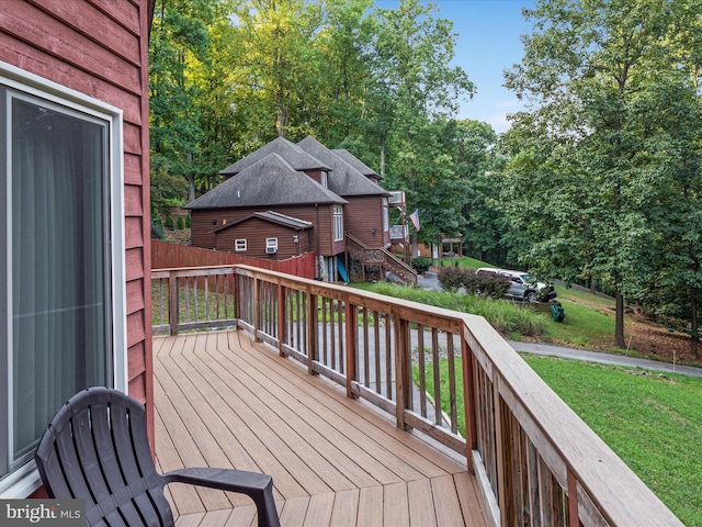 wooden deck featuring a lawn