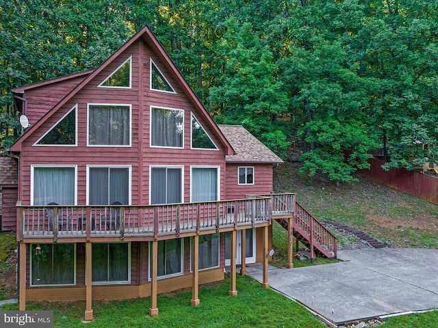 rear view of house featuring a lawn, a patio area, and a deck