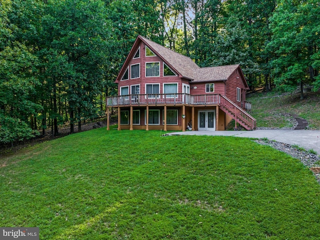 log-style house with a wooden deck, french doors, and a front yard