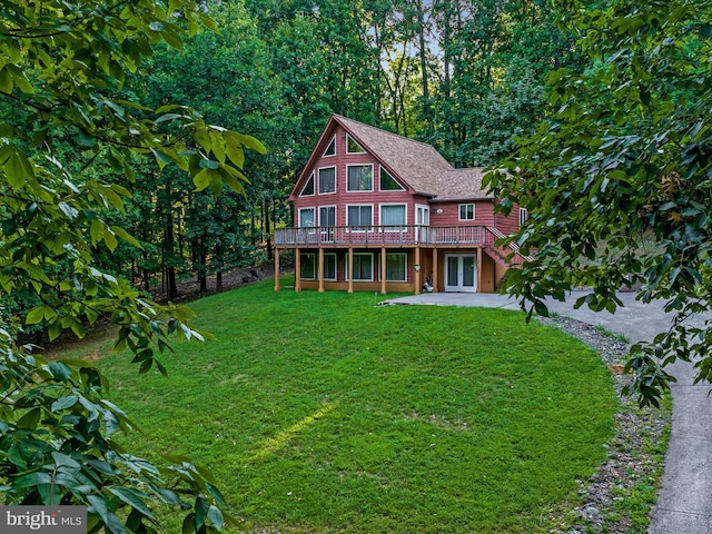 view of front facade with a front yard, a patio, and a deck