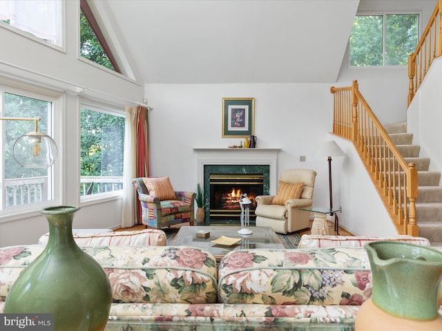 living room with a fireplace and high vaulted ceiling