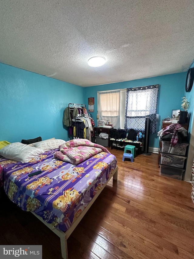 bedroom featuring hardwood / wood-style floors and a textured ceiling