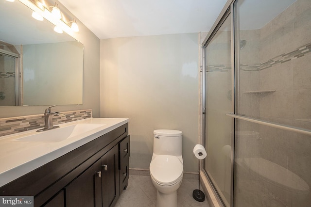 bathroom featuring backsplash, tile patterned floors, vanity, toilet, and a shower with shower door