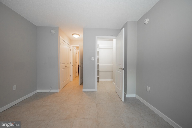 interior space featuring light tile patterned floors and a textured ceiling