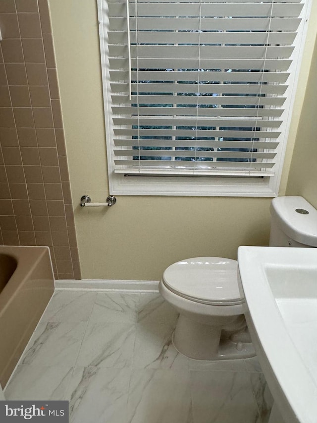 full bathroom featuring separate shower and tub, sink, and toilet