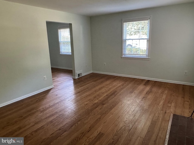 unfurnished room featuring dark hardwood / wood-style floors and a wealth of natural light