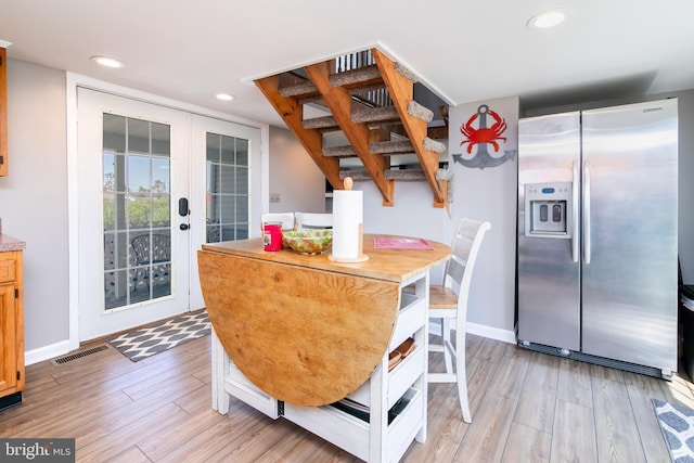 dining room with french doors and light wood-type flooring