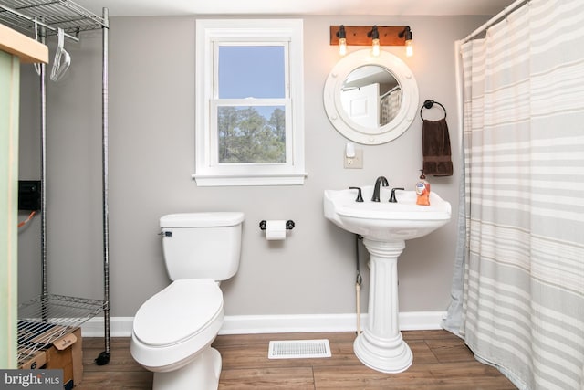 bathroom featuring hardwood / wood-style flooring and toilet