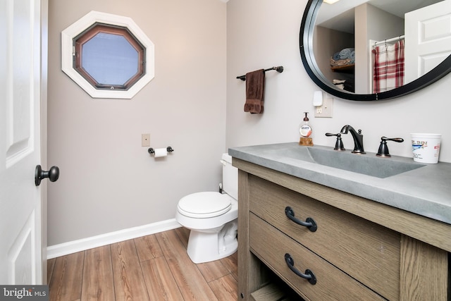 bathroom with hardwood / wood-style flooring, vanity, and toilet