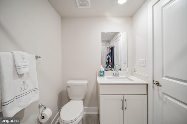 bathroom featuring curtained shower, hardwood / wood-style flooring, vanity, and toilet