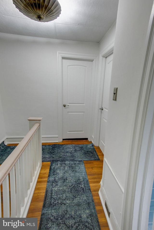 hallway with hardwood / wood-style flooring